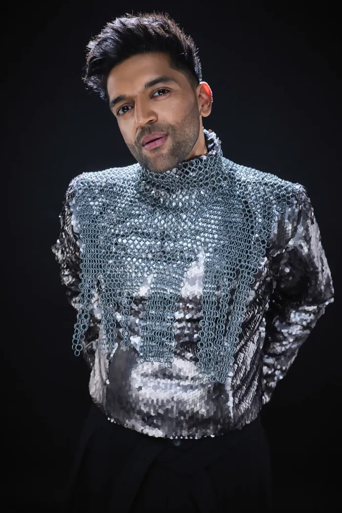 Guru Randhawa in a silver sequin jacket, smiling